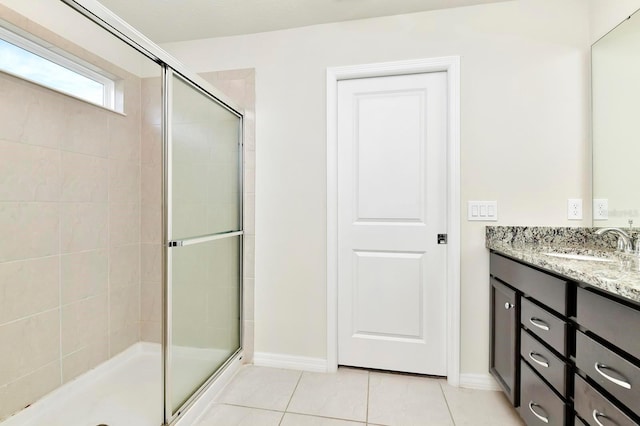 full bath with tile patterned flooring, a shower stall, vanity, and baseboards