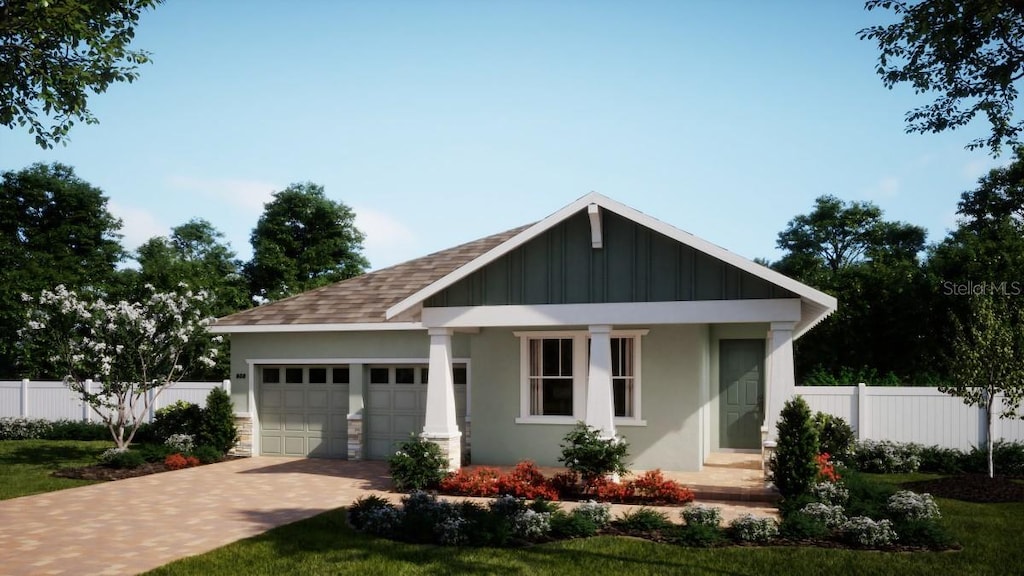 craftsman inspired home with a garage, fence, decorative driveway, board and batten siding, and stucco siding