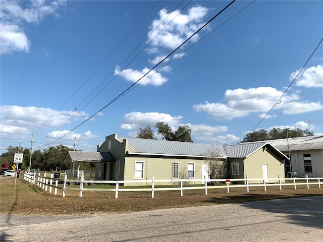 view of front facade with a fenced front yard and metal roof