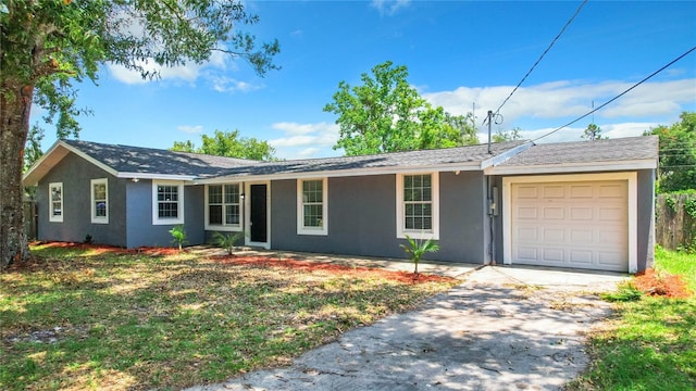 ranch-style home featuring driveway, an attached garage, and stucco siding