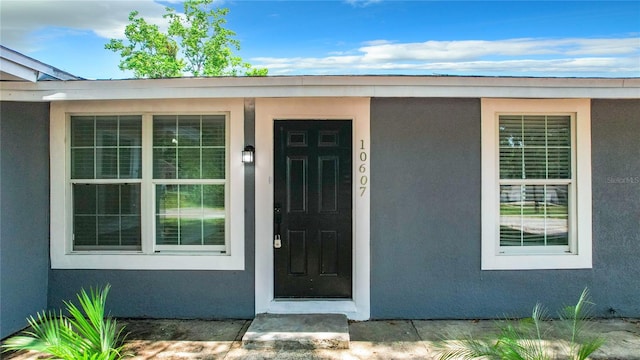 entrance to property featuring stucco siding