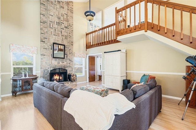 living area with a fireplace, baseboards, and wood finished floors