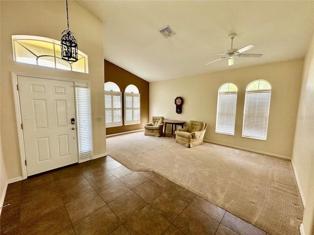 foyer with dark colored carpet, visible vents, a ceiling fan, dark tile patterned floors, and baseboards