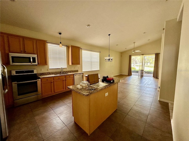 kitchen featuring lofted ceiling, stainless steel appliances, a kitchen island, a sink, and open floor plan