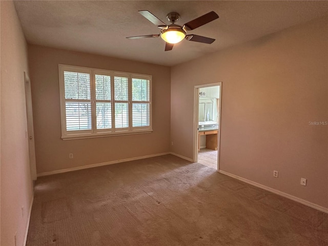 empty room with ceiling fan, carpet floors, and baseboards