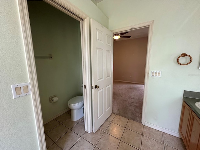 bathroom featuring toilet, a ceiling fan, vanity, tile patterned flooring, and baseboards