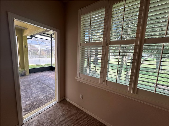 doorway featuring carpet and baseboards