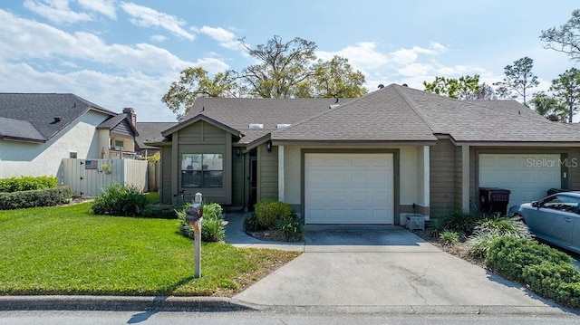 single story home with an attached garage, a shingled roof, fence, concrete driveway, and a front yard