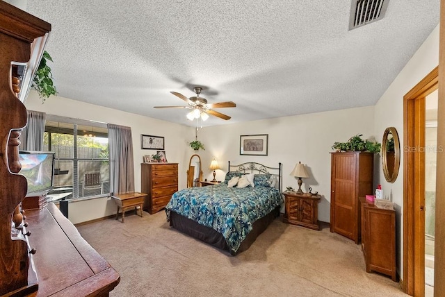 bedroom with light colored carpet, visible vents, a ceiling fan, a textured ceiling, and baseboards