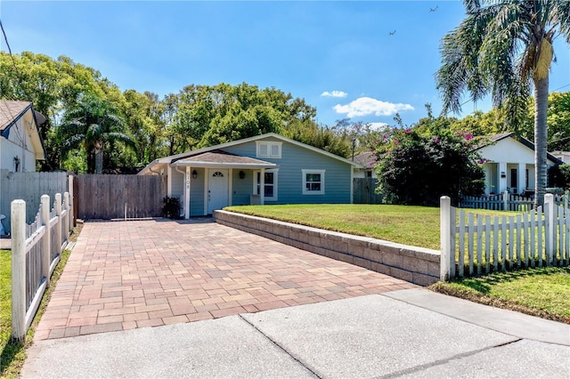 view of front of house featuring a fenced front yard, decorative driveway, and a front lawn