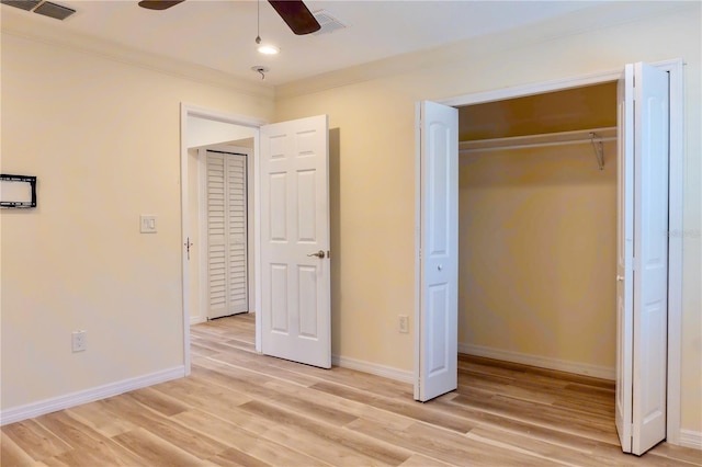 unfurnished bedroom featuring light wood finished floors, visible vents, a closet, and baseboards