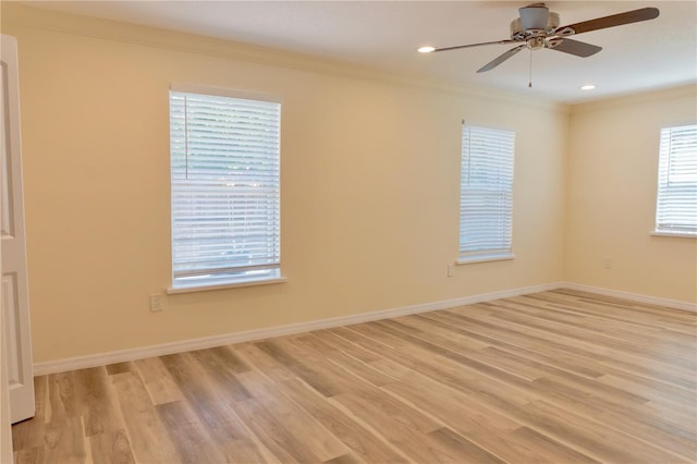 unfurnished room featuring baseboards, light wood-style flooring, and crown molding