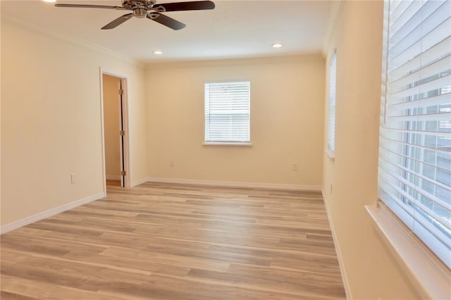 spare room with ornamental molding, baseboards, light wood finished floors, and ceiling fan