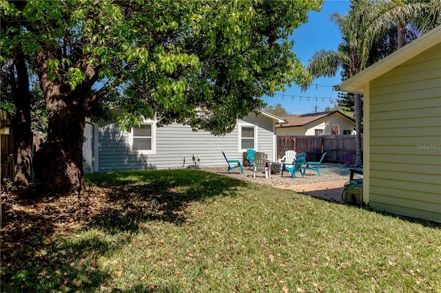 view of yard with fence and a fire pit