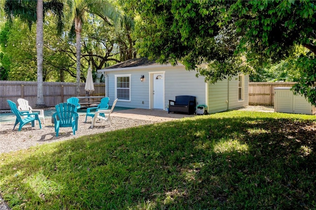 exterior space with an outbuilding, a fenced backyard, and a patio area