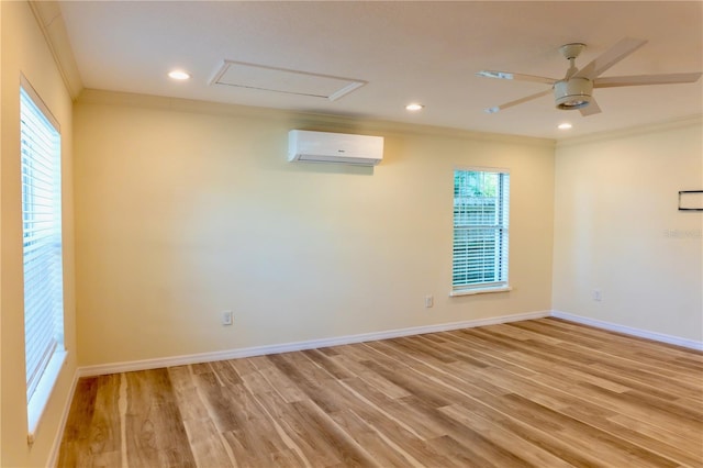 unfurnished room with crown molding, light wood-style flooring, baseboards, and a wall mounted air conditioner