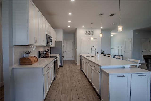2720 Bancroft Blvd, Orlando, FL 32833 - kitchen with tasteful backsplash, a sink, visible vents, appliances with stainless steel finishes, and wood finished floors