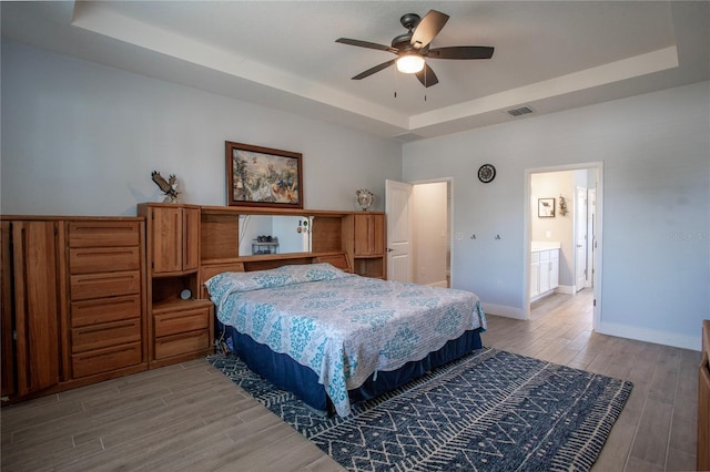 2720 Bancroft Blvd, Orlando, FL 32833 - bedroom featuring a tray ceiling, baseboards, visible vents, and wood finished floors