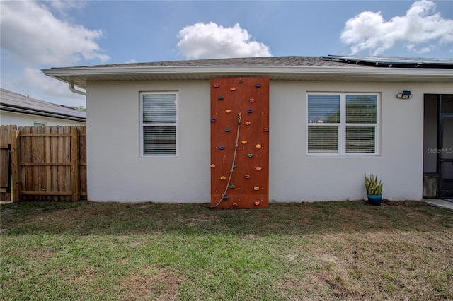 2720 Bancroft Blvd, Orlando, FL 32833 - back of house with a lawn, fence, roof mounted solar panels, and stucco siding