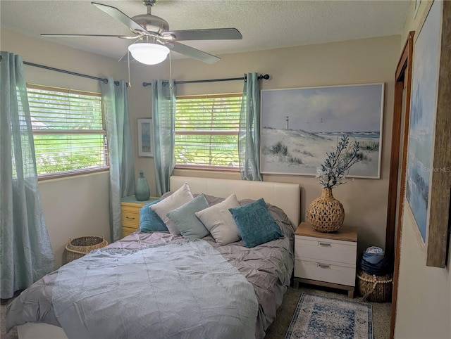 bedroom featuring multiple windows, a ceiling fan, and a textured ceiling