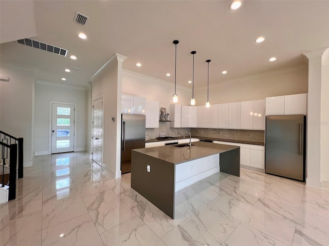 kitchen with visible vents, a sink, modern cabinets, stainless steel fridge, and built in refrigerator