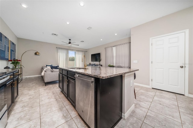 kitchen featuring stainless steel appliances, a sink, visible vents, open floor plan, and light stone countertops