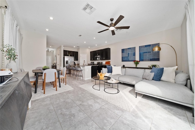 living room with visible vents, a ceiling fan, and recessed lighting