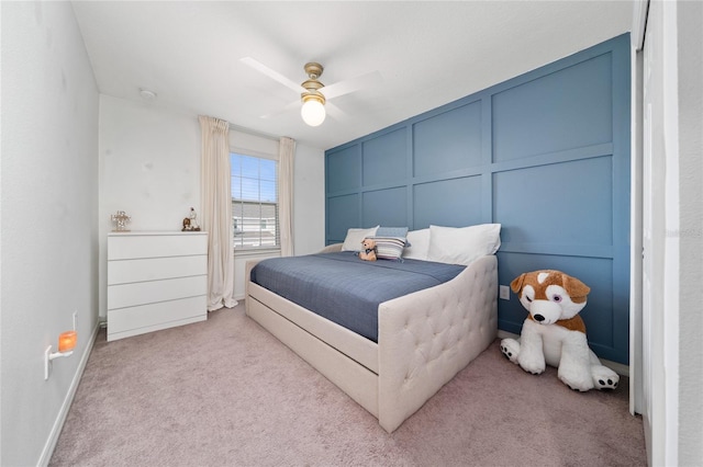 bedroom with baseboards, carpet flooring, a ceiling fan, and a decorative wall