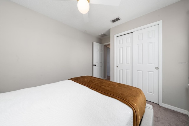 bedroom featuring a closet, visible vents, light carpet, ceiling fan, and baseboards