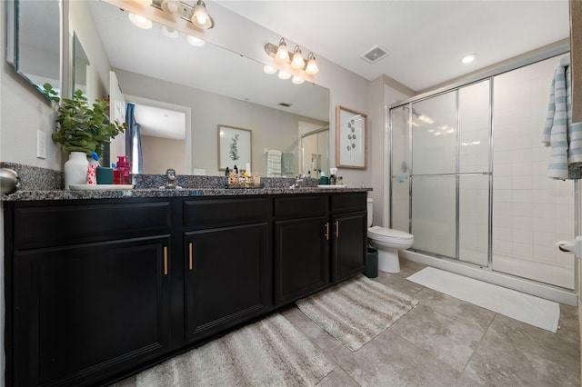 bathroom with double vanity, visible vents, toilet, a stall shower, and a sink