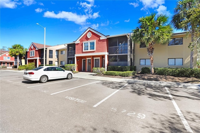 view of building exterior with uncovered parking and a residential view