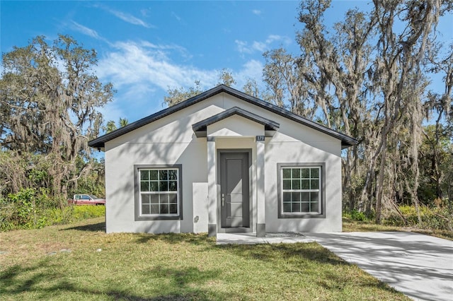 view of front of home with a front lawn and stucco siding