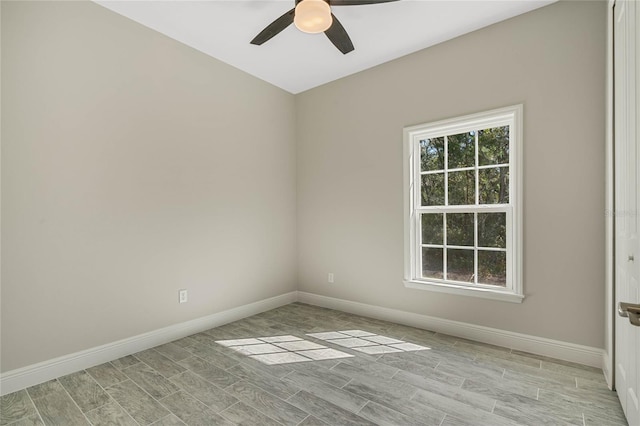 spare room with wood tiled floor, a healthy amount of sunlight, and baseboards