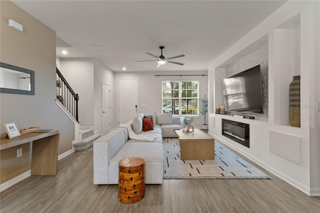 living room featuring baseboards, a ceiling fan, stairway, wood finished floors, and recessed lighting