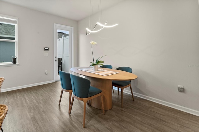 dining space featuring baseboards and wood finished floors