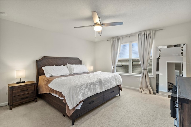 bedroom featuring baseboards, ceiling fan, a textured ceiling, and light colored carpet