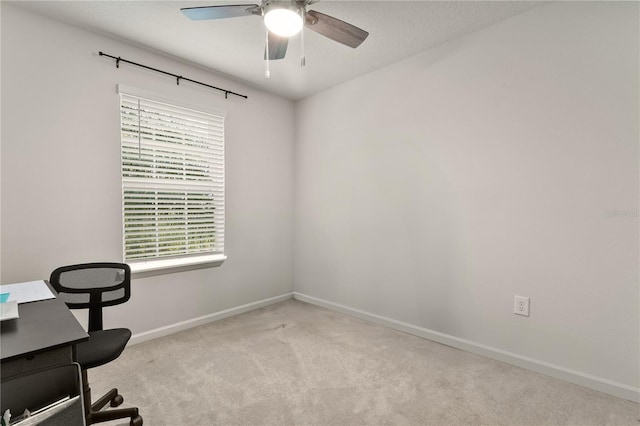 unfurnished office with carpet floors, baseboards, and a ceiling fan