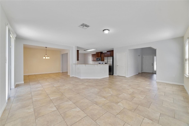 unfurnished living room featuring a chandelier, visible vents, baseboards, and light tile patterned floors