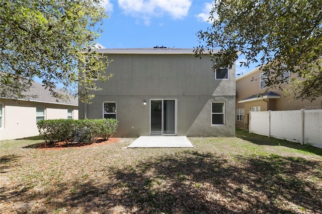 back of property with a patio, a lawn, fence, and stucco siding