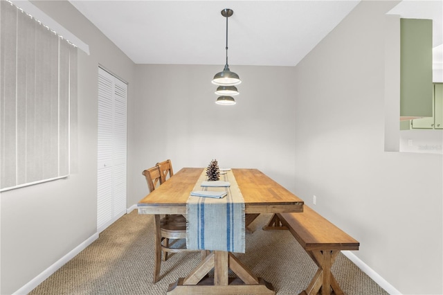 dining space featuring baseboards and carpet