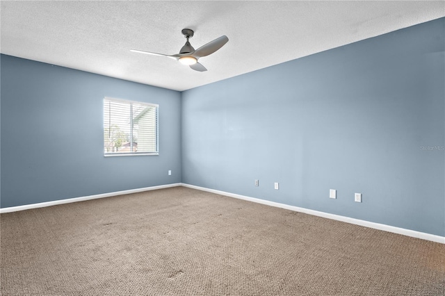 carpeted spare room featuring a textured ceiling, baseboards, and ceiling fan