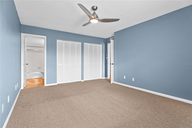 unfurnished bedroom with ceiling fan, two closets, baseboards, and carpet floors