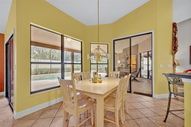 dining area featuring light tile patterned floors, baseboards, and an inviting chandelier