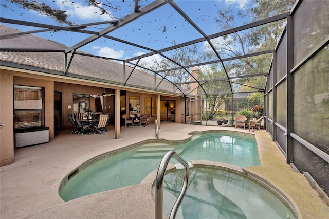 view of pool featuring a patio area, a pool with connected hot tub, glass enclosure, and ceiling fan