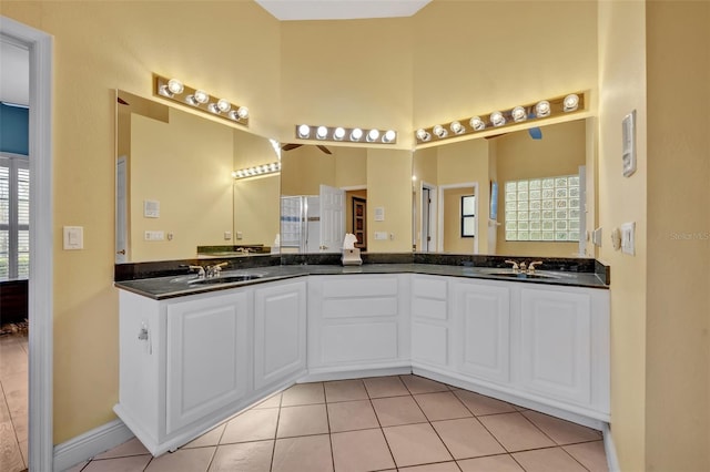 full bathroom with double vanity, tile patterned flooring, and a sink