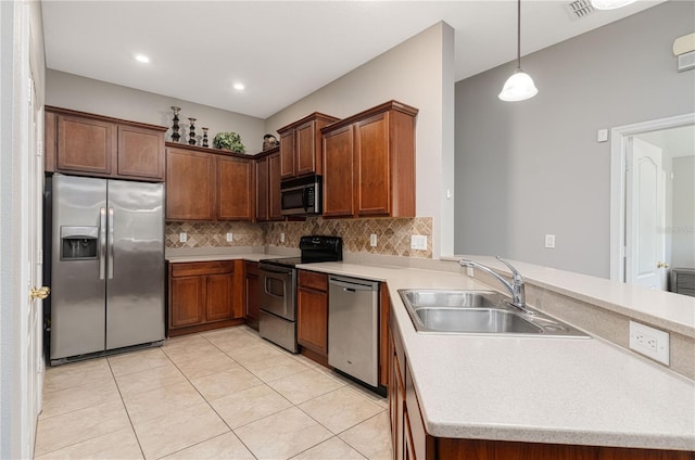 kitchen featuring stainless steel appliances, backsplash, a sink, and a peninsula