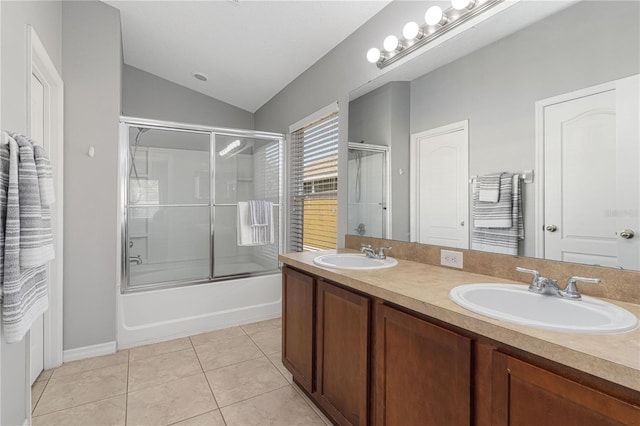 full bathroom with vaulted ceiling, bath / shower combo with glass door, tile patterned flooring, and a sink