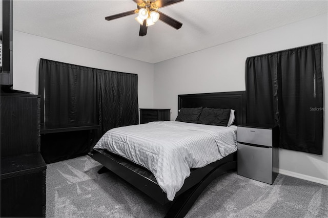 carpeted bedroom featuring ceiling fan and a textured ceiling