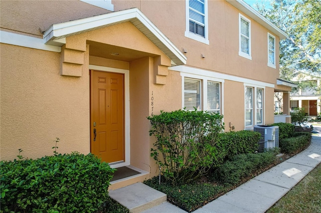 entrance to property with central AC and stucco siding