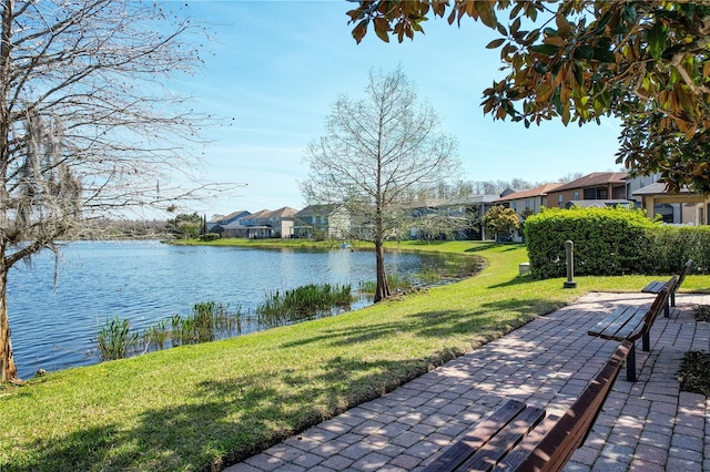 exterior space featuring a lawn, a water view, and a residential view